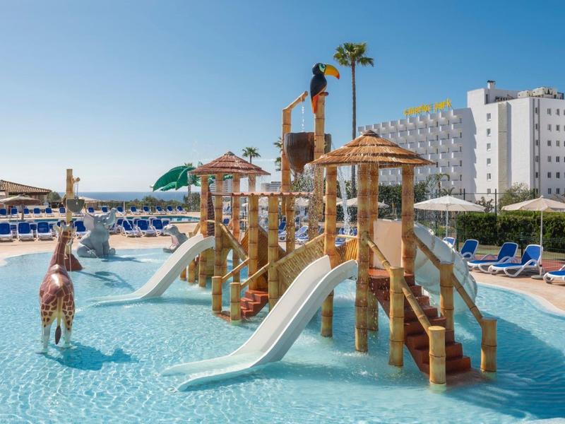 Grande piscina per bambini con scivoli e sdraio in un hotel vicino al mare.