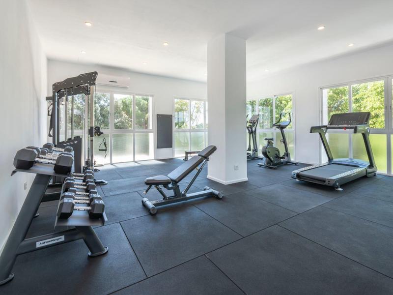 Palestra luminosa con attrezzi moderni e ampie finestre con vista sul giardino.