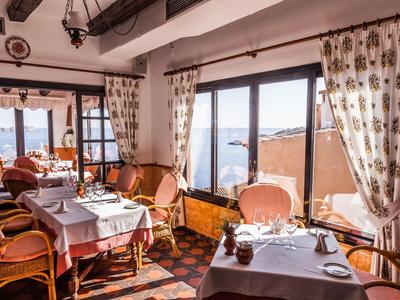 Gemütlicher Essbereich mit großen Fenstern und Meerblick in einem Hotelrestaurant.