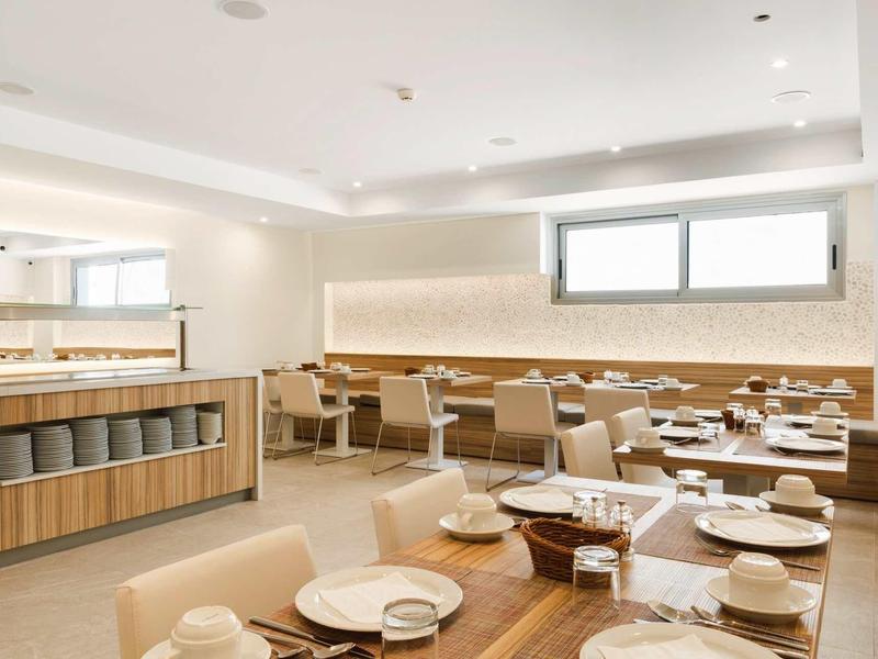 Jasna, nowoczesna restauracja z nakrytymi stołami i drewnianymi panelami na ścianie.