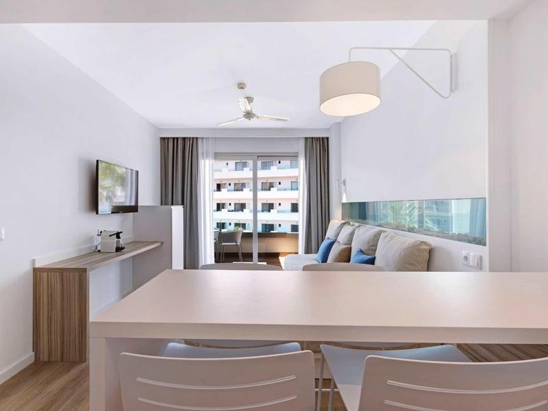 Nowocześnie urządzony salon z balkonem i widokiem na sąsiednie budynki