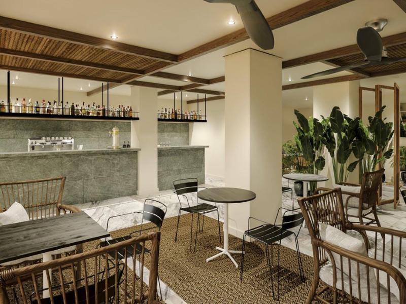 Ambiente interno del bar arredato in modo moderno con posti a sedere e piante.