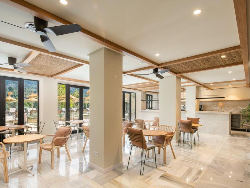 Ampia e luminosa sala da pranzo con arredamento moderno e grandi finestre con vista sulle montagne.