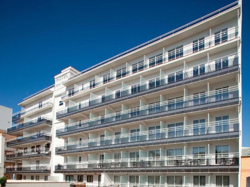 Moderní hotelový komplex s více patry a balkony pod jasnou oblohou.