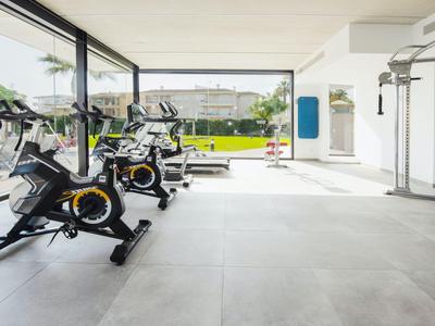 Bright gym with modern stationary bikes and large windows overlooking the outdoor area.