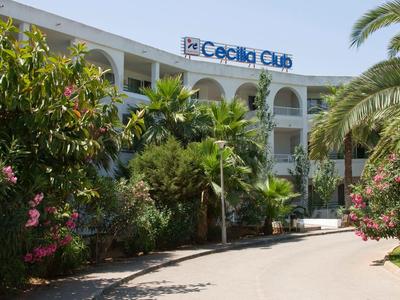 Hotel con insegna 'Cecilia Club' circondato da rigogliosa vegetazione e palme