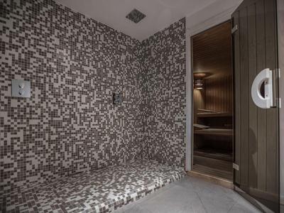 Moderne sauna met mozaïektegels en houten interieur voor ontspanning in hotel.