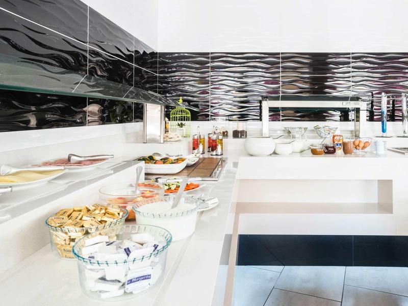 Buffet avec divers plats sur un comptoir blanc dans une pièce moderne.