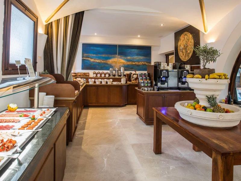 Luxuriöses Buffet mit frischen Speisen, großen Fenstern und elegantem, hellem Innenraum.