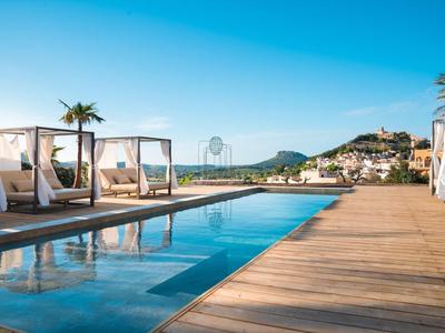 Area piscina moderna con letti bianchi, terrazza in legno e palme in un paesaggio soleggiato.