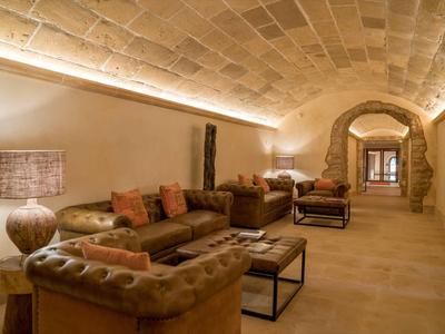 Accogliente area lounge con divani in pelle e archi a volta in pietra in un hotel.