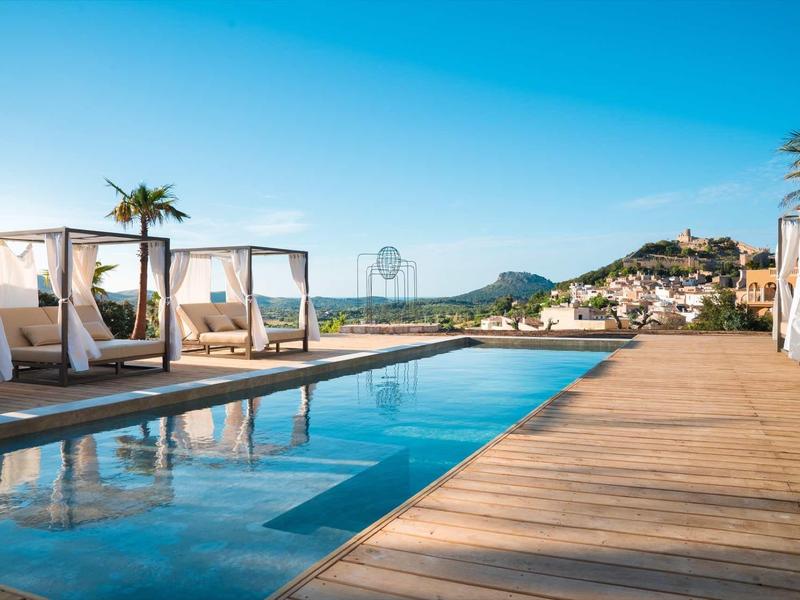 Nowoczesny basen z leżakami i widokiem na wzgórza przy czystym niebie