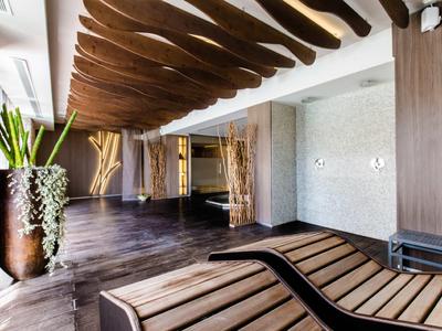 Nowoczesne lobby hotelowe z drewnianymi panelami, dekoracyjnymi wazami i drewnianymi fotelami.