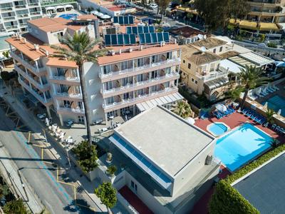 Vista di un hotel con pannelli solari e piscina in una posizione soleggiata.