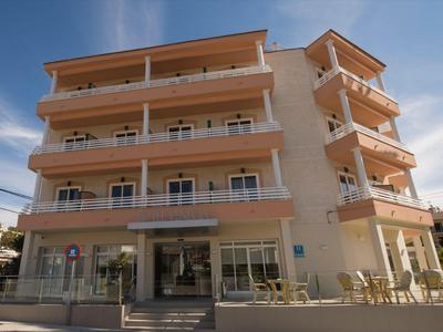 Edificio alberghiero moderno con balconi e grandi finestre sotto un cielo sereno.