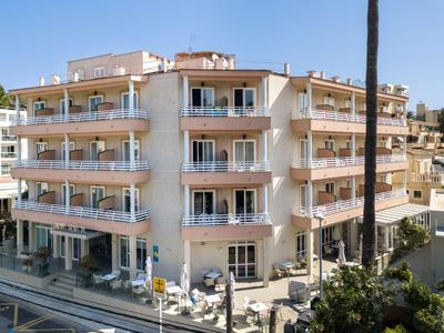 Hotel su più piani con balconi e posti a sedere all'aperto sotto un cielo sereno.