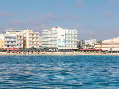 Meerdere hotels en een boulevard aan zee onder een zonnige blauwe lucht.