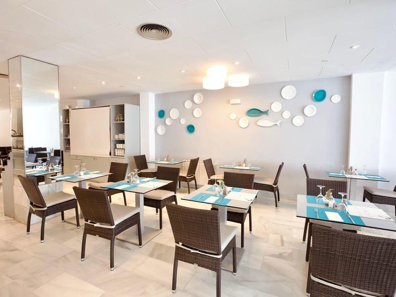 Ristorante moderno e luminoso con pareti bianche e sedie marroni in un'atmosfera rilassata.