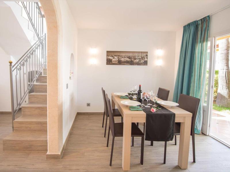 Nowoczesna jadalnia z drewnianym stołem, krzesłami i bezpośrednim wyjściem do ogrodu.