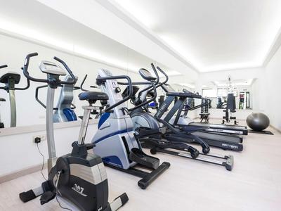 Moderner Fitnessraum mit Trainingsgeräten in hellem, sauberem Raum.