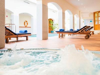 Wewnętrzna strefa spa z bulgoczącym jacuzzi i leżakami