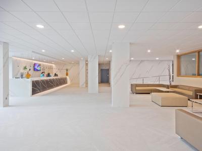 Moderner Hotel-Lobby mit weißem Marmor und beigen Sitzbereichen