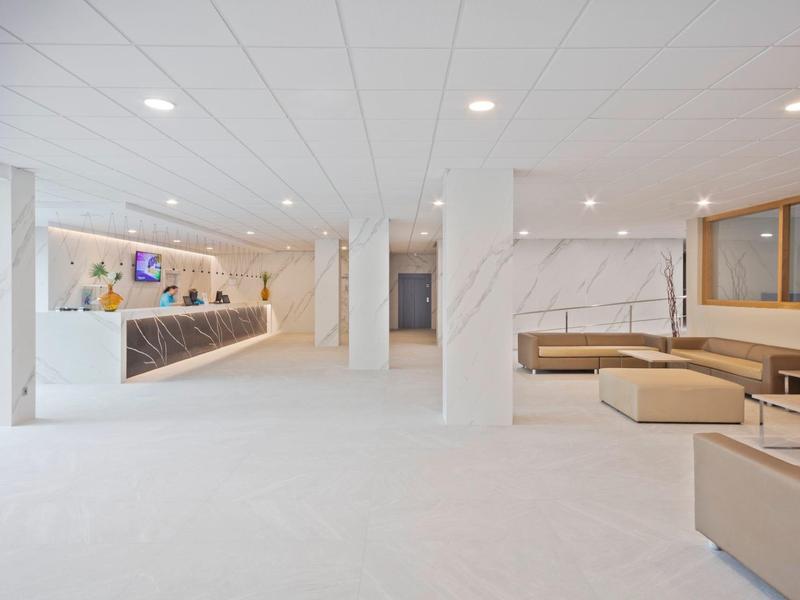 Moderní, prostorná hotelová hala s bílým designem a pohodlným posezením.
