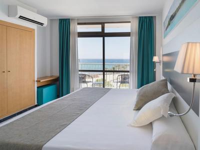 Modern hotel room with double bed, sea view, and air-conditioned window