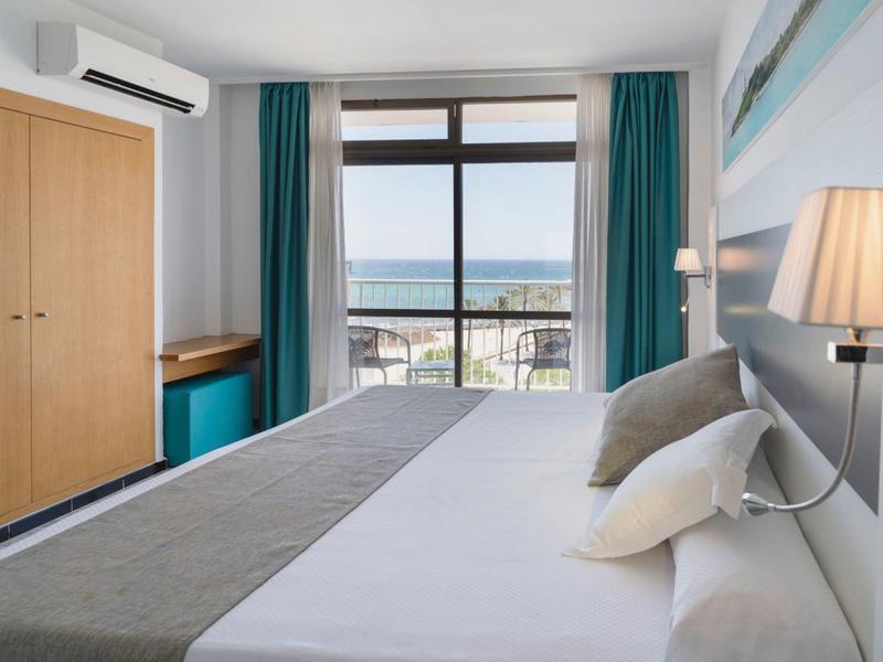 Modern hotel room with double bed, sea view, and air-conditioned window