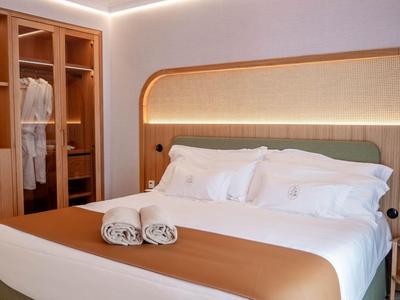 Modern eingerichtetes Schlafzimmer mit Doppelbett, beleuchtetem Kleiderschrank und entspannter Atmosphäre.