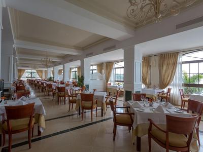 Elegant restaurant with set tables and large windows overlooking the outdoors.