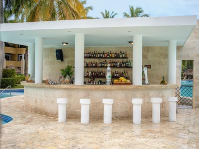 Moderner, offener Poolbarbereich mit hohen Hockern und Spirituosenregalen im Freien.