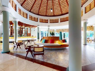 Spacious circular hotel lobby area with seating and a wooden dome ceiling.