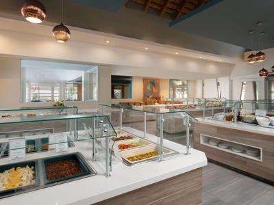 Buffetbereich in einem modernen Hotel mit verschiedenen Gerichten und beleuchtetem Deckenlicht.