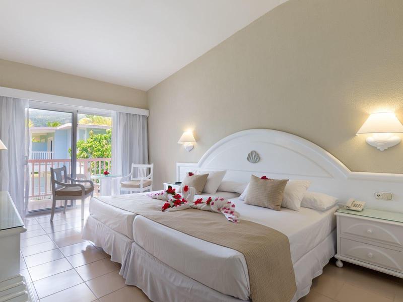 Modernes Hotelzimmer mit Doppelbett, Kommode, Balkon und natürlichem Licht