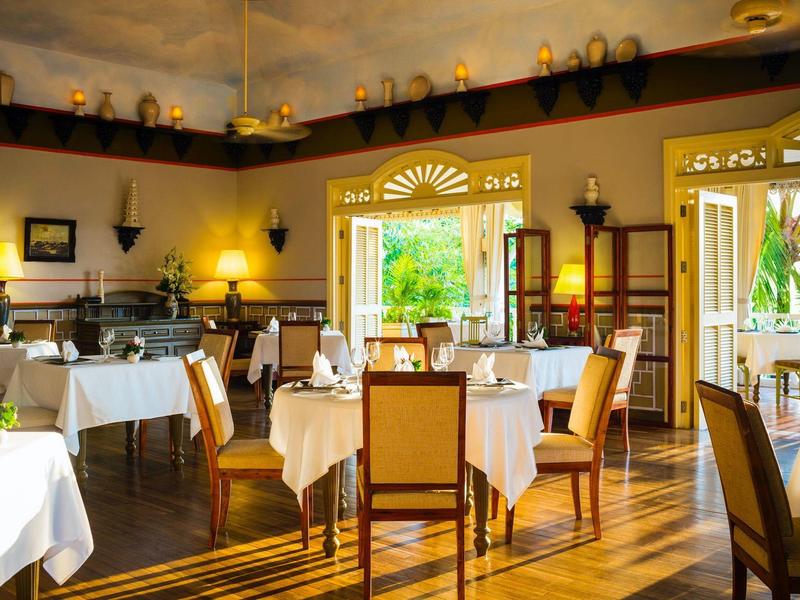 Elegant restaurant with light wooden furniture and view of a green outdoor area