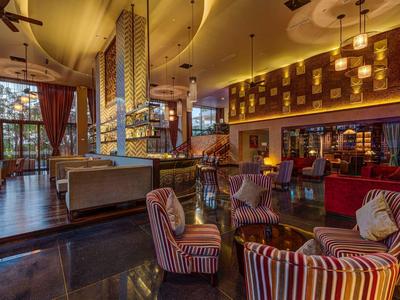 Acogedor bar de hotel con sillones acolchados y luz cálida por la noche.