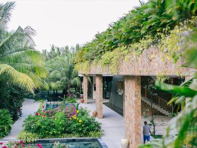 Hotel mit einem mit Pflanzen bedeckten Dach und tropischem Garten im Freien