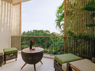 Balcón con muebles de exterior y vista a un área verde, ideal para relajarse en vacaciones.