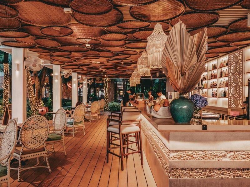 Bar de hotel excepcional con techo de madera, decoración exótica y áreas de estar acogedoras.