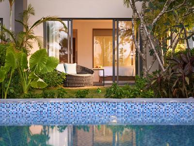 Blick auf einen Pool und eine angrenzende Terrasse mit Gartenmöbeln in einem Hotelzimmer.