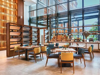 Modernes Restaurant mit großem Glasfenster, Holzmöbeln und bequemen Sesseln