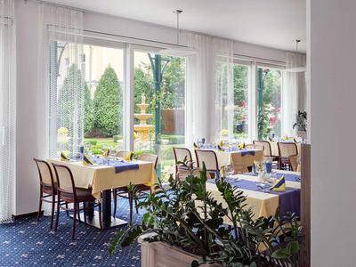 Hell eingerichteter Essbereich mit großen Fenstern und Blick auf Garten