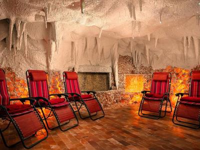 Relaxation room with red lounge chairs in a salt-decorated cave.