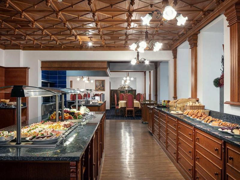 Buffet area with warm wood decor and lit food displays in a hotel.