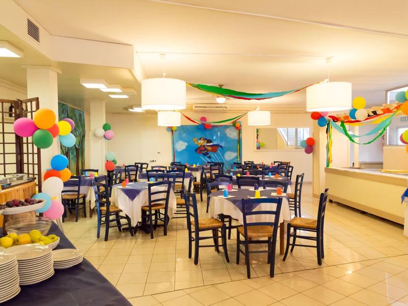 Ein festlich dekorierter Raum mit bunten Luftballons und gedeckten Tischen für Feierlichkeiten.