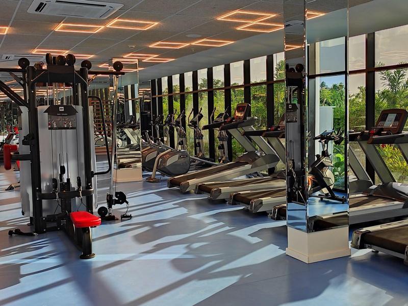 Moderne sportschool met loopbanden en krachtapparatuur in een lichte ruimte met grote ramen.