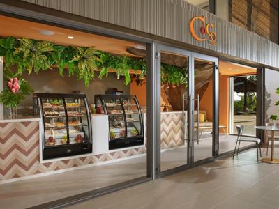 Caffè moderno e aperto con vetrine in vetro e arredamento accogliente.