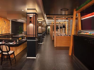 Sala da pranzo dell'hotel moderna con mobili in legno e illuminazione elegante.