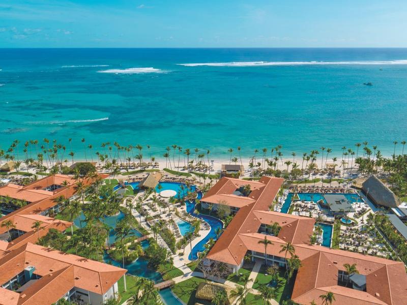 Vista di un resort sulla spiaggia con piscine e palme vicino al mare turchese